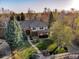 Breathtaking aerial showcasing a beautiful brick house with mature trees, blue skies, and mountain views at 2464 Ginny Way, Lafayette, CO 80026