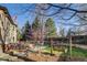 Serene backyard featuring a wooden swing, deck, mature trees, and landscaping, perfect for enjoying the outdoors at 2464 Ginny Way, Lafayette, CO 80026