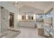 Modern bathroom featuring double vanities, a glass shower, and a soaking tub with tile surround at 2464 Ginny Way, Lafayette, CO 80026