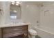 Clean and modern bathroom with bright white tile and a wood vanity at 2464 Ginny Way, Lafayette, CO 80026