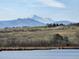 Expansive landscape with a serene lake, rolling hills, and majestic snow-capped mountains in the background at 2464 Ginny Way, Lafayette, CO 80026