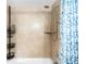 Bathroom shower stall featuring neutral tile, chrome shower head, and storage at 7780 W 38Th Ave # 203, Wheat Ridge, CO 80033