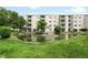 Beautiful exterior view of condo building, including a pond with a fountain and well-manicured landscaping at 7780 W 38Th Ave # 203, Wheat Ridge, CO 80033