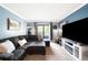 Comfortable living room features a sectional sofa, flatscreen TV, and access to a balcony at 7780 W 38Th Ave # 203, Wheat Ridge, CO 80033