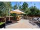 A beautiful outdoor deck area with dining and seating with views of mature trees and string lights at 327 Ingleton Ct, Castle Pines, CO 80108