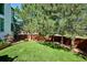 Spacious, well-manicured backyard featuring lush green grass, privacy fence, and mature trees at 327 Ingleton Ct, Castle Pines, CO 80108