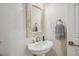 Chic half bath with ornate framed mirror, pedestal sink, and modern fixtures at 327 Ingleton Ct, Castle Pines, CO 80108