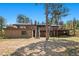 Expansive brick home featuring a large backyard, deck, and multiple staircases, surrounded by mature trees at 7845 Armadillo Trl, Evergreen, CO 80439