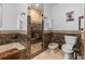 Full bathroom with stand up shower, bath tub, bidet and tiled accent walls at 7845 Armadillo Trl, Evergreen, CO 80439