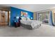 Bright bedroom with a king bed, blue accent wall, and balcony access to a hot tub at 7845 Armadillo Trl, Evergreen, CO 80439