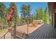 Large deck with seating, a hot tub, and views of the surrounding trees at 7845 Armadillo Trl, Evergreen, CO 80439