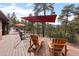 Spacious deck boasts outdoor seating with an umbrella and mountain views at 7845 Armadillo Trl, Evergreen, CO 80439