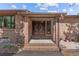 Covered front entrance with brick pillars and a decorative double door with a decorative, circular glass panel at 7845 Armadillo Trl, Evergreen, CO 80439