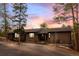 Charming brick home with a well-manicured front yard, mature trees, and a long driveway at 7845 Armadillo Trl, Evergreen, CO 80439