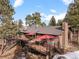 Home exterior with deck, landscaping, and hot tub at 7845 Armadillo Trl, Evergreen, CO 80439