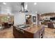 Large kitchen island with cooktop, sink, and stainless steel vent hood at 7845 Armadillo Trl, Evergreen, CO 80439