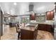 Spacious kitchen features a large island with a cooktop and stainless steel vent hood at 7845 Armadillo Trl, Evergreen, CO 80439