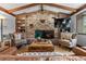 Cozy living room with a stone fireplace, wood beams, and comfortable seating at 7845 Armadillo Trl, Evergreen, CO 80439