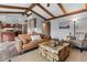 Open-concept living room with hardwood floors, a stylish sofa, and access to the kitchen at 7845 Armadillo Trl, Evergreen, CO 80439