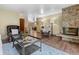 Spacious living room featuring a stone fireplace, hardwood floors, and comfortable leather seating at 7845 Armadillo Trl, Evergreen, CO 80439