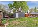 Beautifully landscaped backyard with patio, fire pit area, shed, and mature trees at 1343 Gay St, Longmont, CO 80501