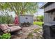 Landscaped backyard with stone patio, cozy seating, and a gray shed with a red floral design at 1343 Gay St, Longmont, CO 80501