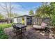 Stone backyard patio featuring outdoor dining and lounge areas, plus a yellow-doored shed at 1343 Gay St, Longmont, CO 80501