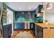 Charming kitchen featuring sleek stainless-steel appliances, stylish blue cabinets and a vibrant tile backsplash at 1343 Gay St, Longmont, CO 80501