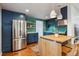 Stylish kitchen with blue cabinets, modern appliances, and a unique backsplash at 1343 Gay St, Longmont, CO 80501