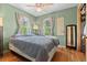 Cozy bedroom with hardwood floors, two windows, ceiling fan and green painted walls at 661 Tennyson St, Denver, CO 80204