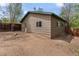 Exterior view of tan home with green trim, wooden fence and dirt yard at 661 Tennyson St, Denver, CO 80204