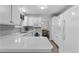 Well-lit kitchen with a gray backsplash, white cabinets, stainless steel appliances, and a view of the dining area at 4350 E 112Th Pl, Thornton, CO 80233