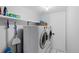 Bright laundry room featuring white front loading washer and dryer and storage shelving at 4350 E 112Th Pl, Thornton, CO 80233