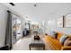 Bright living room featuring hardwood floors, an orange sofa, and access to the outdoor patio through sliding doors at 4350 E 112Th Pl, Thornton, CO 80233