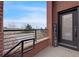 Charming covered front porch entry with a brick pillar and black railing on a sunny day at 5471 W 97Th Pl # F, Broomfield, CO 80020