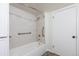 Bright bathroom featuring tile walls, safety grab bars, and a white bathtub and shower combination at 1266 S Telluride St, Aurora, CO 80017