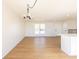 Spacious living room with wood floors, a modern chandelier, and access to the kitchen and front door at 1266 S Telluride St, Aurora, CO 80017