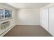 Bedroom with a window, carpet flooring, baseboard heater, and closet with sliding doors at 1391 Vance St, Lakewood, CO 80214