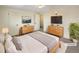 A staged bedroom features two dressers, a cozy bed, and a decorative plant at 1391 Vance St, Lakewood, CO 80214