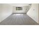 An empty living room with neutral carpet, white walls, and a large window for great natural light at 1391 Vance St, Lakewood, CO 80214