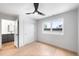Bright bedroom with hardwood floors, a ceiling fan, large window, and an ensuite bathroom at 2520 S Cherokee St, Denver, CO 80223