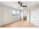 Bright bedroom with hardwood floors, a ceiling fan, and a view into the ensuite bathroom at 2520 S Cherokee St, Denver, CO 80223