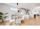 Bright dining area featuring contemporary lighting, a glass table, and views into the modern kitchen at 2520 S Cherokee St, Denver, CO 80223