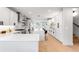 Elegant, all-white kitchen with an island, barstool seating, and high-end stainless steel appliances at 2520 S Cherokee St, Denver, CO 80223