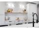 Bright white kitchen features custom cabinets, floating shelf, and contemporary lighting at 2520 S Cherokee St, Denver, CO 80223