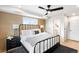 Main bedroom featuring modern ceiling fan, wood accent wall and large windows at 2520 S Cherokee St, Denver, CO 80223
