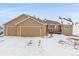 Tan house with a three-car garage and snowy yard at 7295 Sunset Ave, Elizabeth, CO 80107