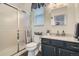 Bright bathroom featuring a shower with glass door, vanity with a sink and neutral-toned walls at 17611 E 104Th Pl, Commerce City, CO 80022