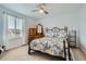 Bedroom featuring a bed with a metal frame, a dresser, and a window with light coming through at 17611 E 104Th Pl, Commerce City, CO 80022