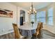 Dining room with a modern chandelier, wood floors, and a large window for natural light at 17611 E 104Th Pl, Commerce City, CO 80022
